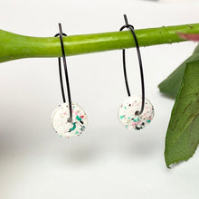 Load image into Gallery viewer, Black hoops with white polymer clay circles on a rose stem