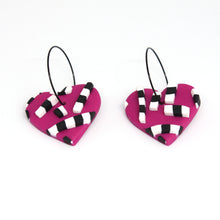 Load image into Gallery viewer, Vibrant pink hearts with 3D black and white striped detailing. Styled with stainless steel black hoops. Lightweight, handcrafted and one of a kind!