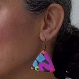 A video still of Vicky from Pink Lime Mango modelling handcrafted Neon Snakes earrings for size reference. Bright, bold and colourful earrings made in Bristol UK
