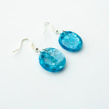 Load image into Gallery viewer, A stunning blue colour in these beautiful resin earrings! Oceans Blue Circle Drops feature chunky aqua eco-glitter and electric blue mica power. Side view.