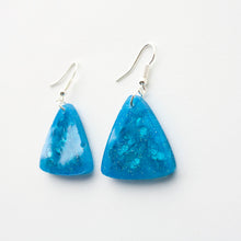 Load image into Gallery viewer, glittery blue resin triangle earrings with silver plated hooks. side view