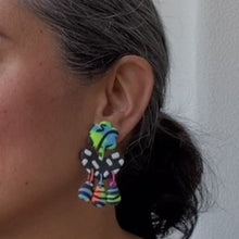 Load image into Gallery viewer, A video still of Vicky from Pink Lime Mango modelling handcrafted earrings for size reference. Bright, bold and colourful Flo earrings made in Bristol UK
