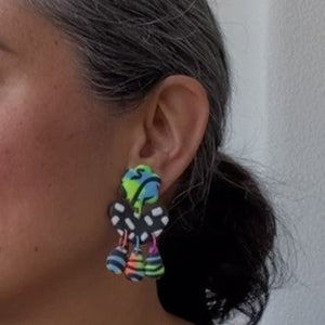 A video still of Vicky from Pink Lime Mango modelling handcrafted earrings for size reference. Bright, bold and colourful Flo earrings made in Bristol UK