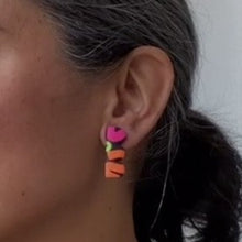 Load image into Gallery viewer, A video still of Vicky from Pink Lime Mango modelling handcrafted earrings for size reference. Bright, bold and colourful Legwarmers earrings made in Bristol UK