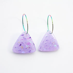 Sparkly lilac triangular earrings from the Under the Sea resin collection. Beautiful layers of fine iridescent glitter, colour shifting aurora flakes and tiny pieces of metallic purple foil. A unique design that has been complimented with multicoloured rainbow hoops! 
