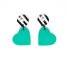 Load image into Gallery viewer, Bright, bold and colouful earrings with black and white striped stud top and a vibrant bright green heart. The earrings are handcrafted from lightweight polymer clay. Handmade by British artist, Vicky, in her home studio in Bristol, UK.