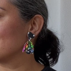 A video still of Vicky from Pink Lime Mango modelling handcrafted earrings for size reference. Bright, bold and colourful Neon Butterfly Switch earrings made in Bristol UK
