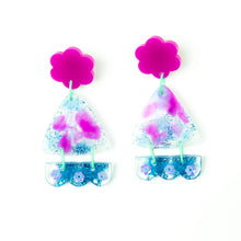 Load image into Gallery viewer, Vibrant handcrafted resin earrings with a pink flower top, the middle parts are frosted white triangles with pink cloud patterns and a sprinkling of electric blue glitter. The base element has sparkly lilac flowers perfectly placed above a layer of electric blue glitter. Complimented with mint green jump rings. Image shows the fronts of the earrings.