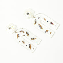 Load image into Gallery viewer, Handcrafted earrings with arches of clear resin containing sea lavender flowers. The stud top is a white flower containing the most wonderful colourful changing aurora flakes of glitter. Image shows the backs of the earrings