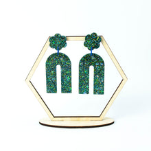 Load image into Gallery viewer, Hexagonal earring display stand. Handcrafted resin arch earrings that are jam packed with sparkly teal blue, green and gold glitter! These beauties have flower stud tops and look fabulous on!

