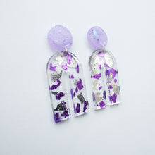 Load image into Gallery viewer, Gorgeous handcrafted resin earrings with round glittery lilac stud tops! These beautiful arch dangle earrings are decorated with delicate pieces of silver and purple foils. Side view.