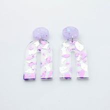 Load image into Gallery viewer, Gorgeous handcrafted resin earrings with round glittery lilac stud tops! These beautiful arch dangle earrings are decorated with delicate pieces of silver and purple foils. Side view.