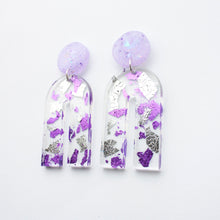 Load image into Gallery viewer, Gorgeous handcrafted resin earrings with round glittery lilac stud tops! These beautiful arch dangle earrings are decorated with delicate pieces of silver and purple foils. Side view.