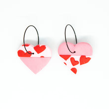Load image into Gallery viewer, Bright, bold and colourful handcrafted earrings from Pink Lime Mango. Split Heart Hoops. One half is pale pink, and the other half is a lighter pink with tiny red hearts.