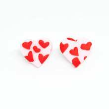Load image into Gallery viewer, Pink and red mini heart studs. A pale pink base heart with tiny red hearts overlaid to give a slightly raised textured pattern.