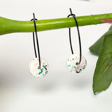 Load image into Gallery viewer, Black hoops with white polymer clay circles on a rose stem
