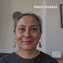 Load and play video in Gallery viewer, A video of Vicky from Pink Lime Mango modelling handcrafted Neon Snakes earrings for size reference. Bright, bold and colourful earrings made in Bristol UK
