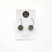 Load image into Gallery viewer, Black glitter sparkly discs on stainless steel black hoops! These feature iridescent glitter which changes between blue, gold and green. Unique and one of a kind!
