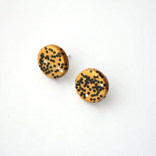 Load image into Gallery viewer, Handcrafted studs in a gold colour overlaid with iridescent glitter which shimmers between gold, green and blue. Plus a sprinkling of black and silver hexagonal glitter. Unique and one of a kind! Featuring silver plated stud posts and earring backs.
