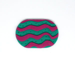 A colourful statement piece of wearable art! A vibrant green tablet shaped brooch with a raised pink squiggle pattern! Featuring intricate texturing done by hand!