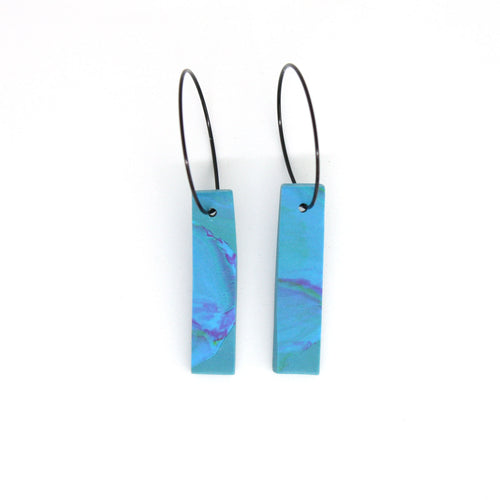 A unique watercolour effect pair of earrings in light blue, pink and yellow.