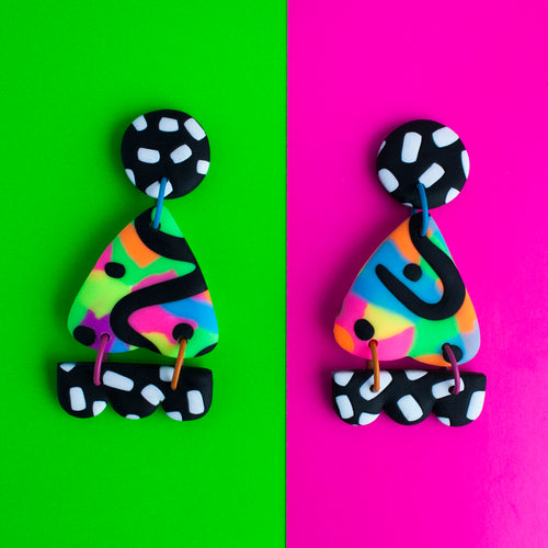 Bright, bold and colourful earrings which have black and white circular stud tops and multicoloured neon triangles with black dots and swirls!