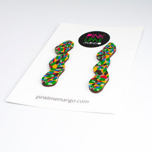 Side view - Statement squiggle earrings with a beautiful mosaic pattern of marbled brown, green, cream, bright red, electric blue, mango orange with a chocolate coloured brown base. Placed on a white backing card with the Pink Lime Mango logo.
