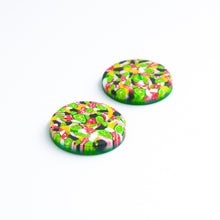 Load image into Gallery viewer, Bright bold and colourful statement studs! They are handcrafted in the UK by Bristol based Artist and Jeweller, Vicky Takooree. The distinctive multi-coloured pattern from Pink Lime Mango includes zesty green lime shapes, dark green, marbled red and white, yellow and pink elements! They are made of very lightweight polymer clay. Side view.
