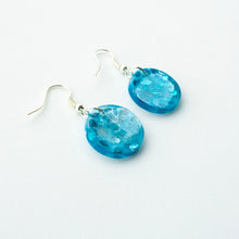 Load image into Gallery viewer, A stunning blue colour in these beautiful resin earrings! Oceans Blue Circle Drops feature chunky aqua eco-glitter and electric blue mica power. Side view.
