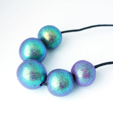 Load image into Gallery viewer, Measurements: each bead is approx 2.5cm Each design is exclusively unique! Featuring an adjustable waxed cotton cord. An absolutely stunning iridescent 5 beaded necklace with purple, green and blue tones. These dazzling colours change with movement! Only one necklace available in this style!
