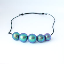 Load image into Gallery viewer, Measurements: each bead is approx 2.5cm Each design is exclusively unique! Featuring an adjustable waxed cotton cord An absolutely stunning iridescent 5 beaded necklace with purple, green and blue tones. These dazzling colours change with movement! Only one necklace available in this style!
