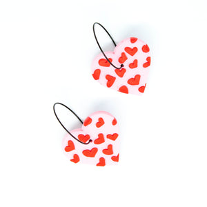 Gratitude Hoops - handcrafted light pink hearts with a small red hearts texture laid across the surface. Attached with black hypoallergenic stainless steel hoops.