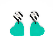 Load image into Gallery viewer, Bright, bold and colouful earrings with black and white striped stud top and a vibrant bright green heart. The earrings are handcrafted from lightweight polymer clay. Handmade by British artist, Vicky, in her home studio in Bristol, UK.
