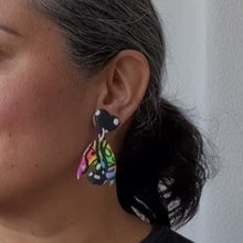 Load image into Gallery viewer, A video still of Vicky from Pink Lime Mango modelling handcrafted earrings for size reference. Bright, bold and colourful Neon Butterfly Switch earrings made in Bristol UK

