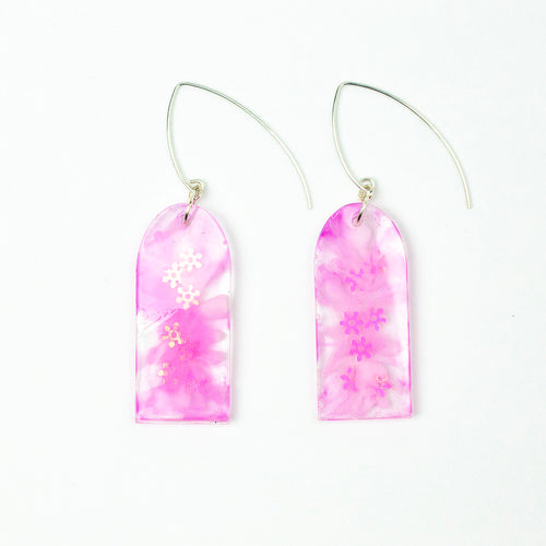 Delicate arches of clear resin with bursts of pale pink and tiny shimmery flower sequins. The unique V shaped earring hooks are made of sterling silver.
