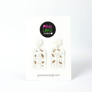 Handcrafted earrings with arches of clear resin containing sea lavender flowers. The stud top is a white flower containing the most wonderful colourful changing aurora flakes of glitter. Earrings are shown on a Pink Lime Mango backing card.