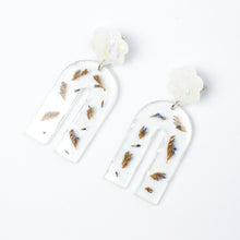 Load image into Gallery viewer, Handcrafted earrings with arches of clear resin containing sea lavender flowers. The stud top is a white flower containing the most wonderful colourful changing aurora flakes of glitter. Side view.
