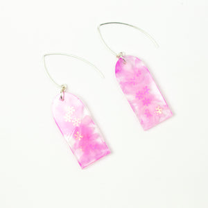Delicate arches of clear resin with bursts of pale pink and tiny shimmery flower sequins. The unique V shaped earring hooks are made of sterling silver. Side view