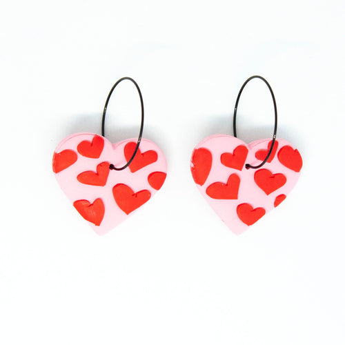 Bright, bold, and colourful with hypoallergenic black hoops. The earrings have been finished with a silky smooth back so they feel luxurious to touch. A beautiful contrast to the raised texture at the front. Each individual red heart has been cut by hand by Vicky, artist and founder of Pink Lime Mango. The heart earrings have a light pink base and are made from lightweight polymer clay.