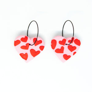 Bright, bold, and colourful with hypoallergenic black hoops. The earrings have been finished with a silky smooth back so they feel luxurious to touch. A beautiful contrast to the raised texture at the front. Each individual red heart has been cut by hand by Vicky, artist and founder of Pink Lime Mango. The heart earrings have a light pink base and are made from lightweight polymer clay.