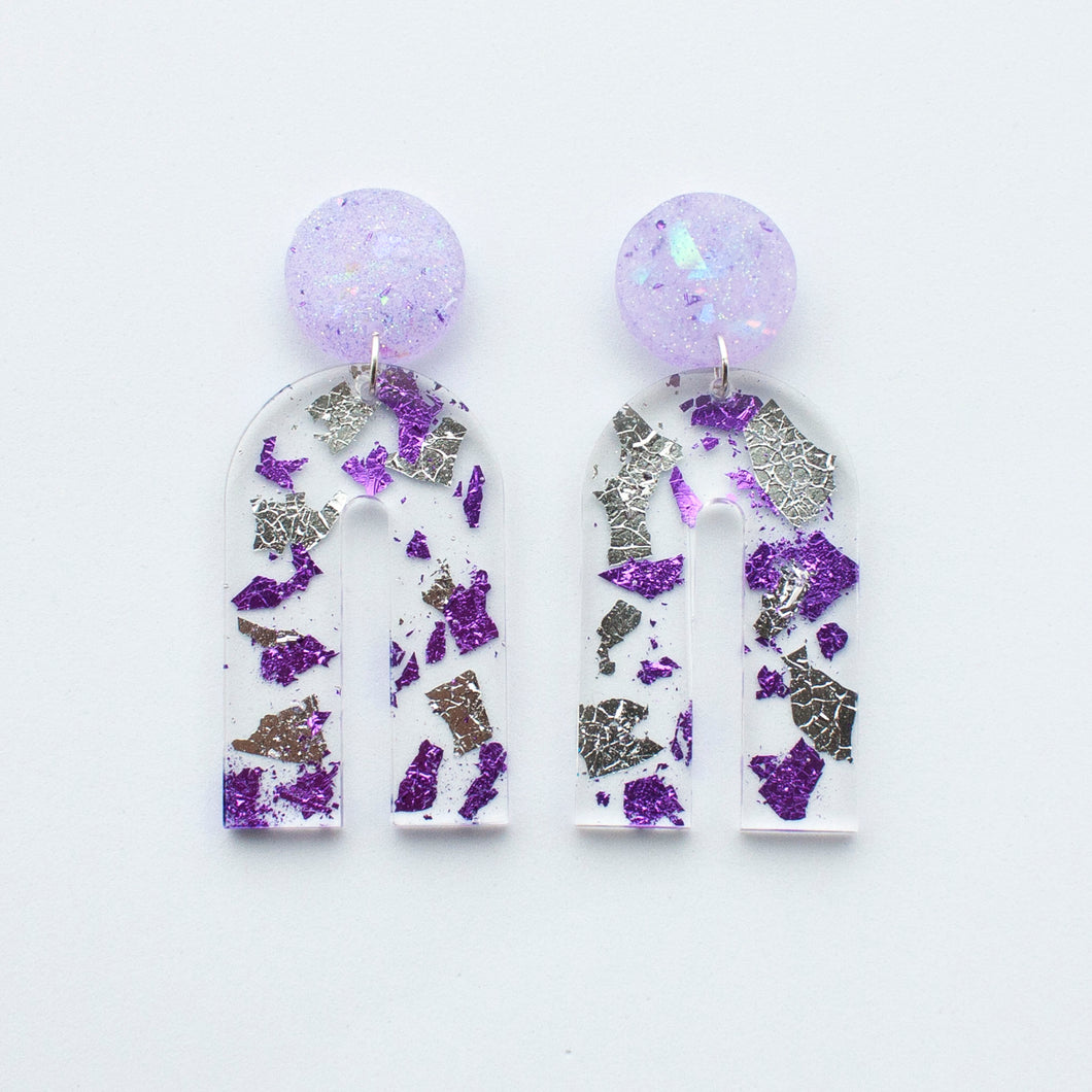 Gorgeous handcrafted resin earrings with round glittery lilac stud tops! These beautiful arch dangle earrings are decorated with delicate pieces of silver and purple foils.