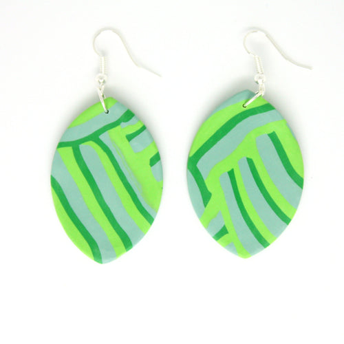 A bold green striped leaf earring on a pale green grey background. Unique design by Pink Lime Mango