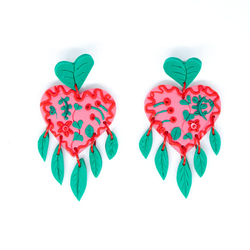 The Green Planet earrings. The stud tops are green leaves that are also abstract heart shapes. The pink heart in the middle is decorated with red and green swirls, minitaure leaves and flowers. The earrings have a delicate fringe of hand cut leaves and they hang beautifully!